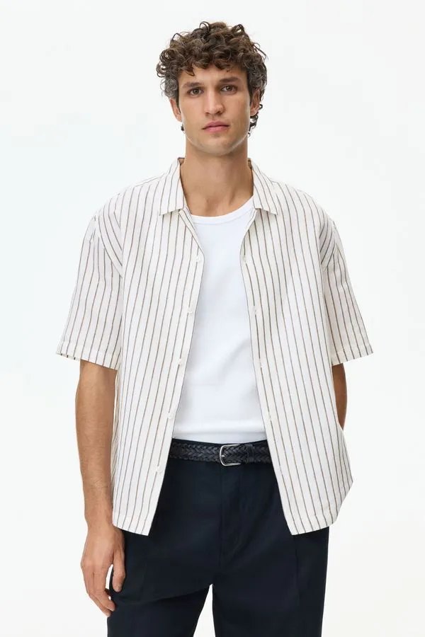 La camisa de rayas abierta sobre polera blanca